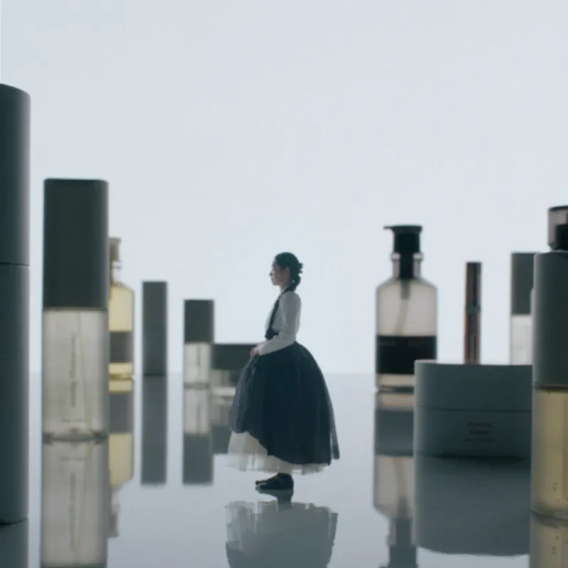 Imagen oficial de RIMAN: mujer con hanbok entre frascos de la marca